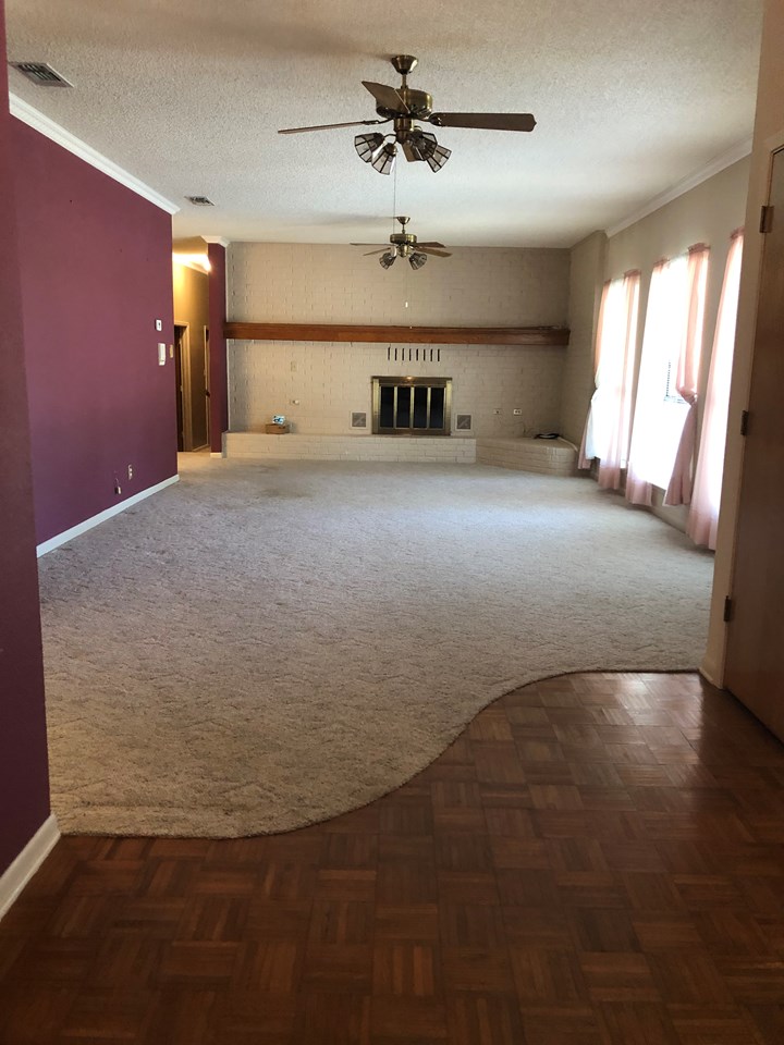 huge living room brick fireplace wall with gas log fireplace, wall of windows looks out to the front circle drive and street