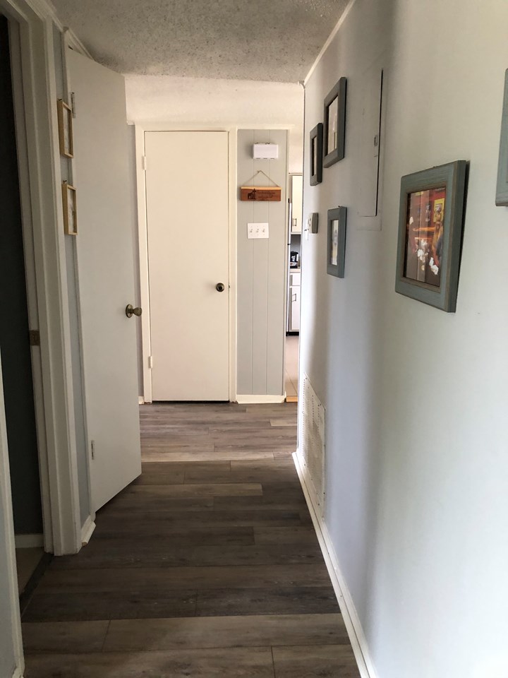 hall way leading to the 2 bedrooms notice the front entry closet and easy to care for luxury vinyl plank flooring.